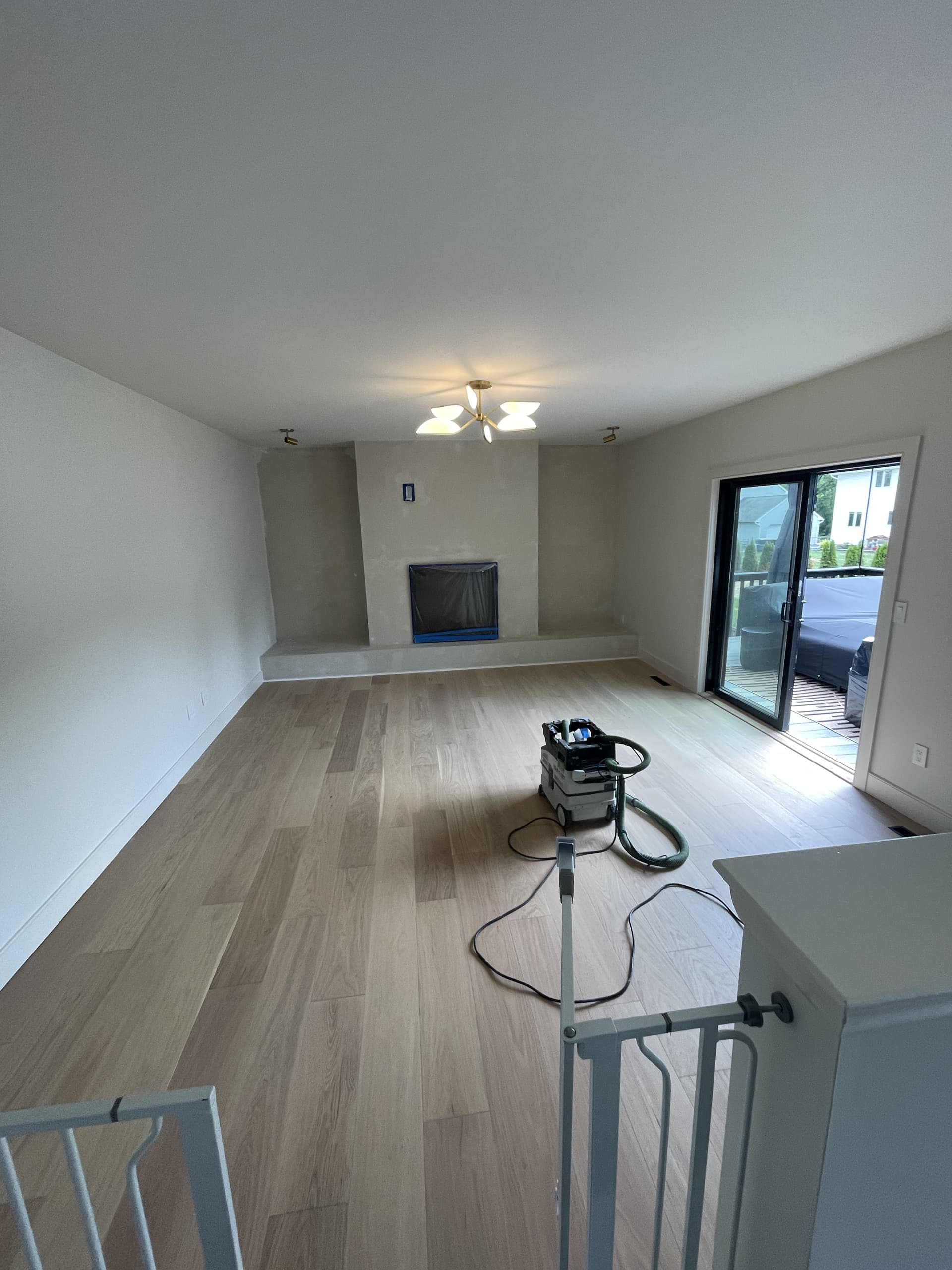 Allentown living area with flooring and trim detailed along the fireplace wall.