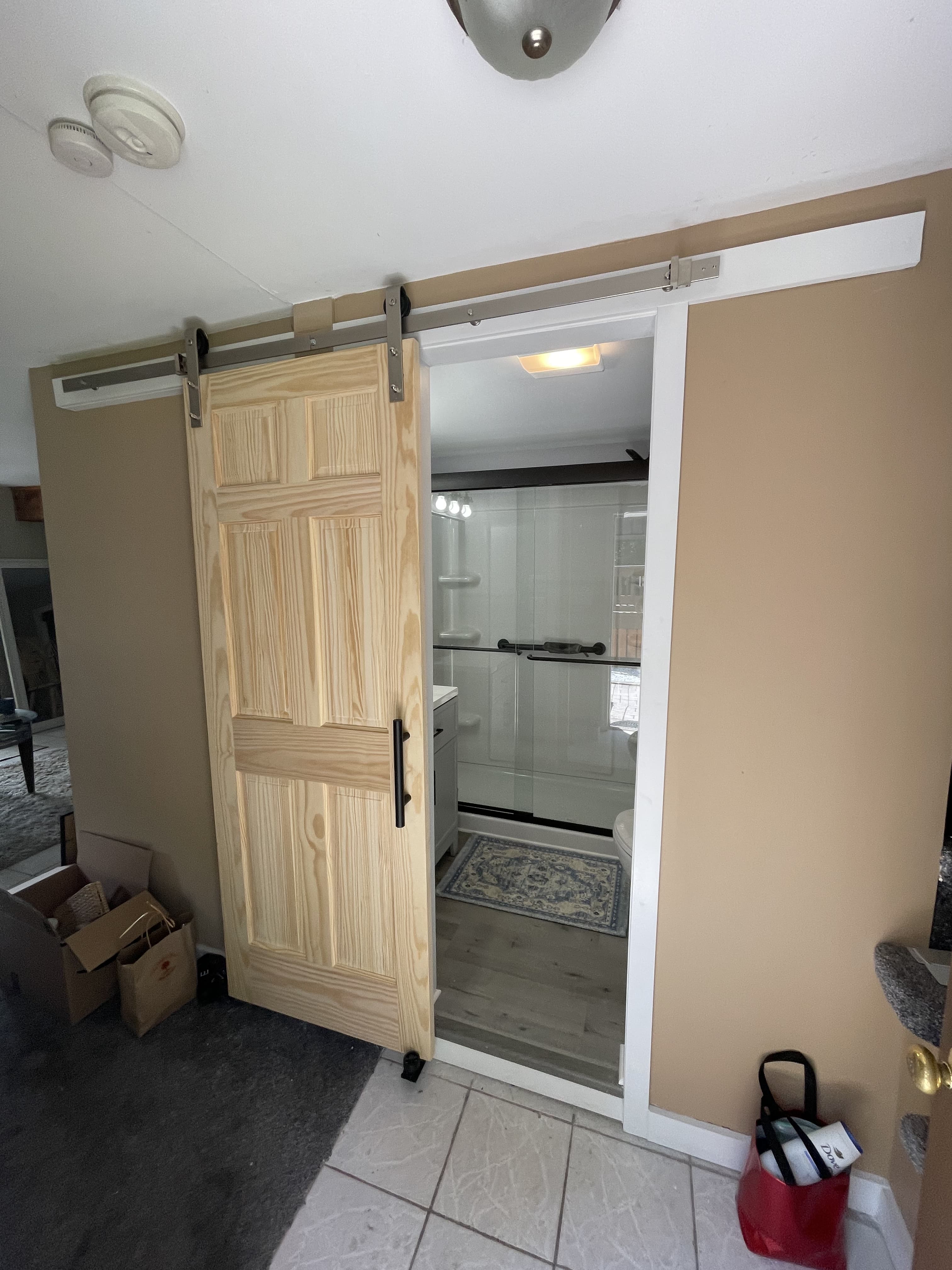 Finished bathroom renovation showing updated vanity, lighting, and new door addition.