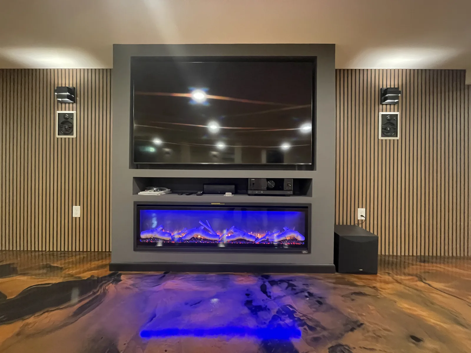 Finished basement media room with large screen.